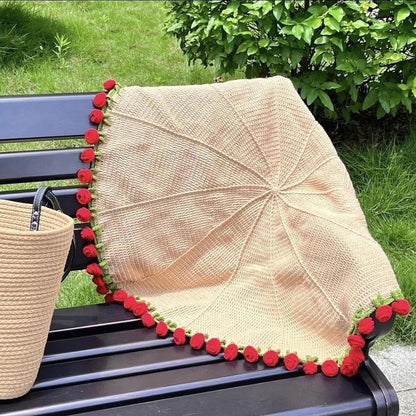 handmade crochet blanket of red roses on bench